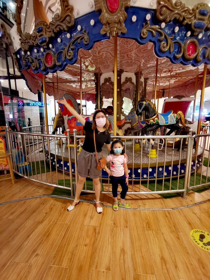 two people in front of a carousel