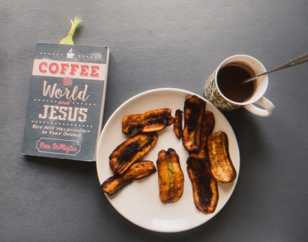 a book, a plate of fried saba bananas, and a cup of sikwate